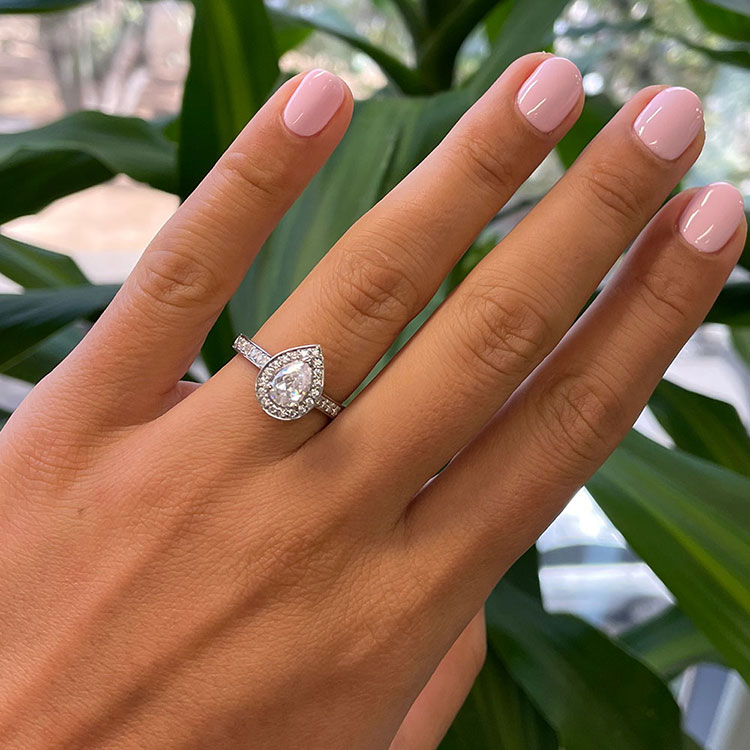 Pear cut diamond engagement ring with pave halo