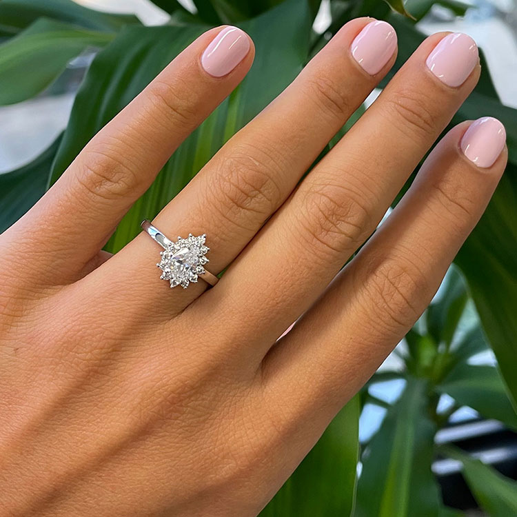 Pear cut diamond engagement ring with a floral diamond halo